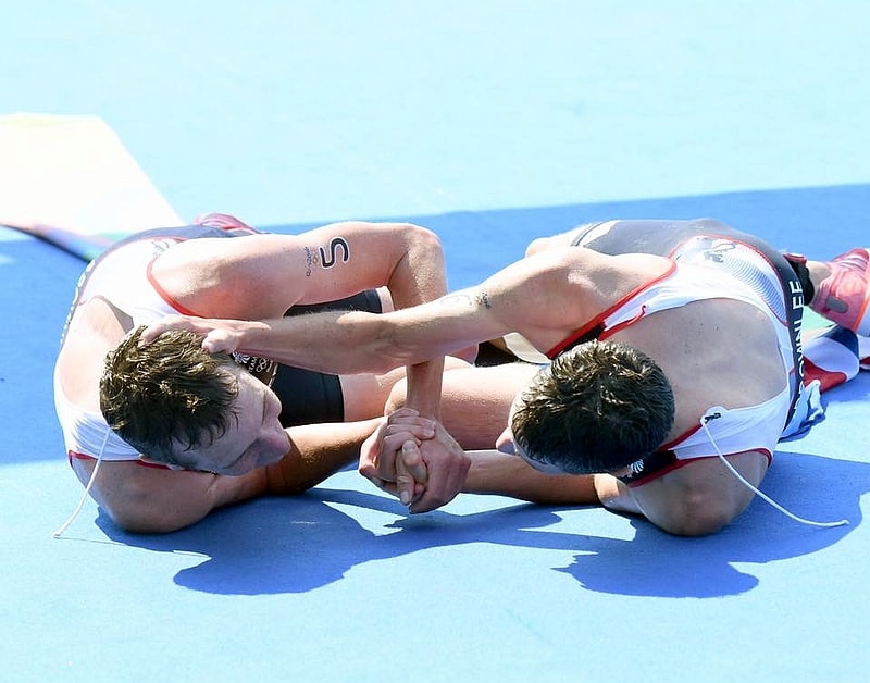 La foto ricordo del triathlon maschile di Rio 2016: i fratelli Brownlee stremati a terra dopo la conquista del 1° e 2° posto