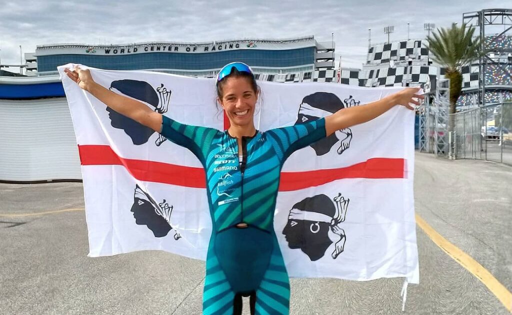 Elisabetta Curridori sorridente con la bandiera dei 4 mori della sua Sardegna, al traguardo del PTO Championship 2020 Challenge Daytona chiuso con un brillantissimo nono posto